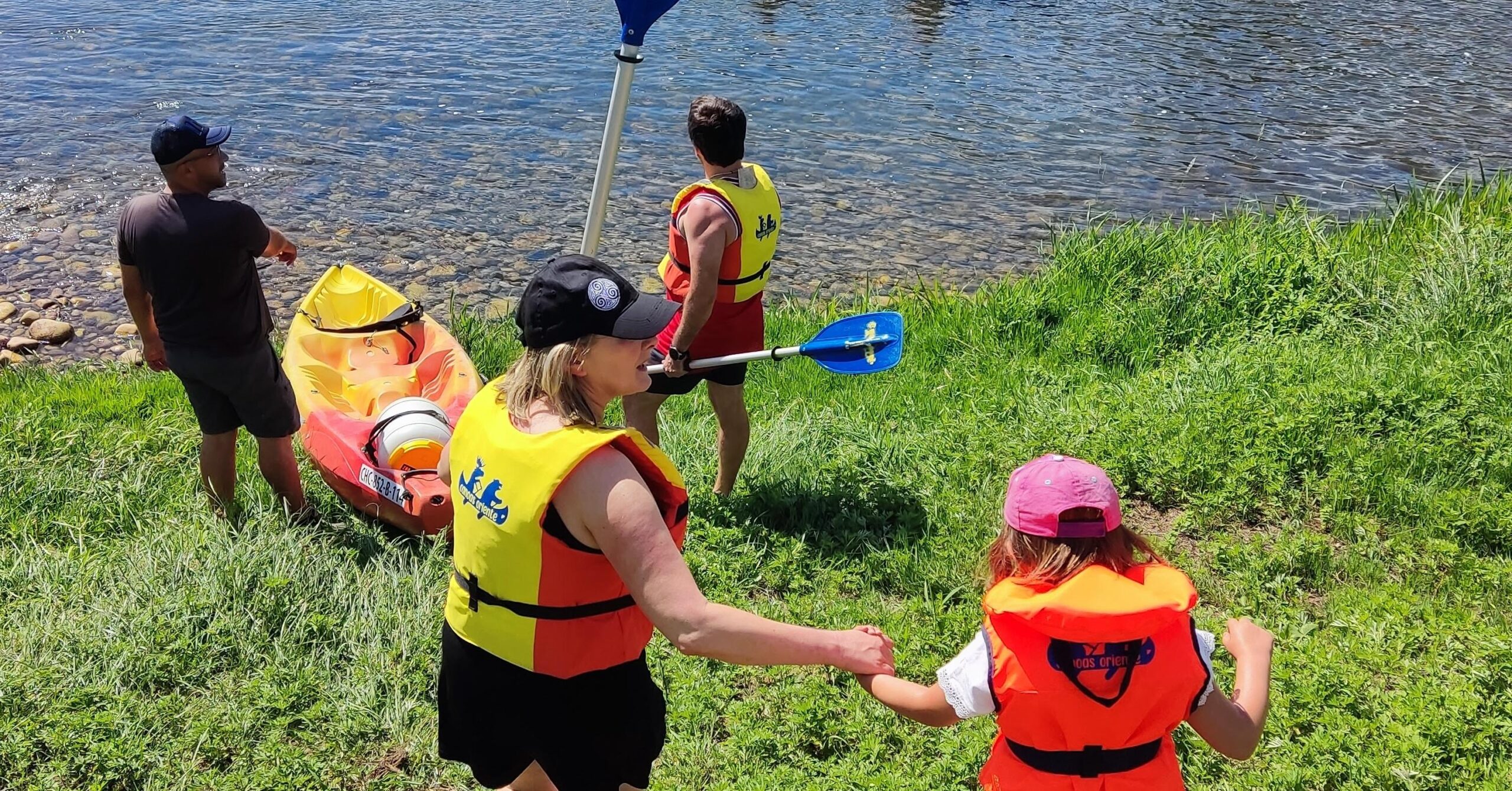Familia preparándose para kayak en el río